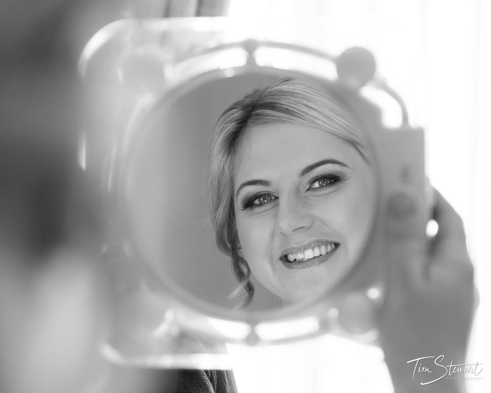 Black and white image of bride looking in mirror at Grinkle Park, North Yorkshire