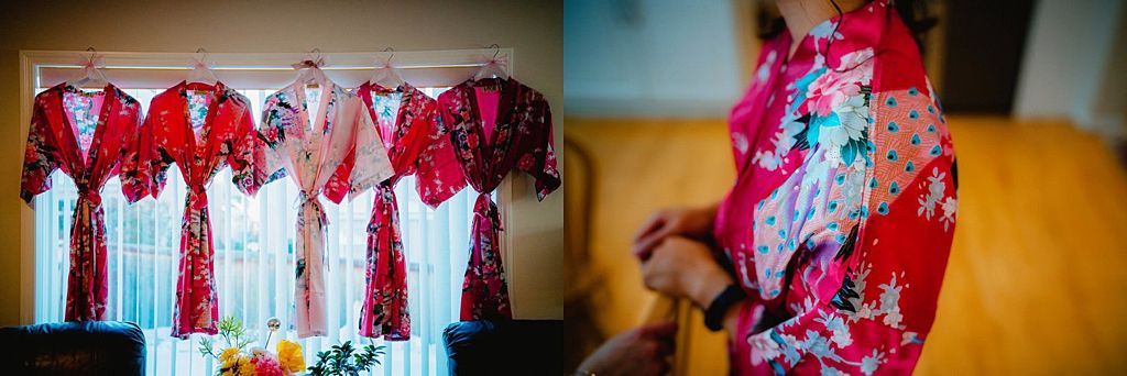 Collection of red and pink floral robes hanging on a rack with detail of fabric pattern.