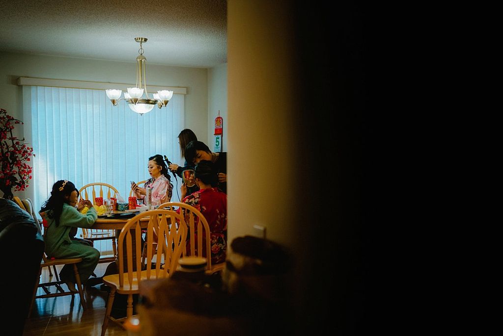 Candid moment at a dining table through a doorway with warm ambient lighting.