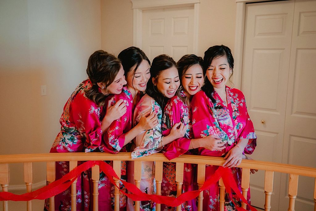 Group wearing matching floral robes gather on stairs for a celebratory photo.