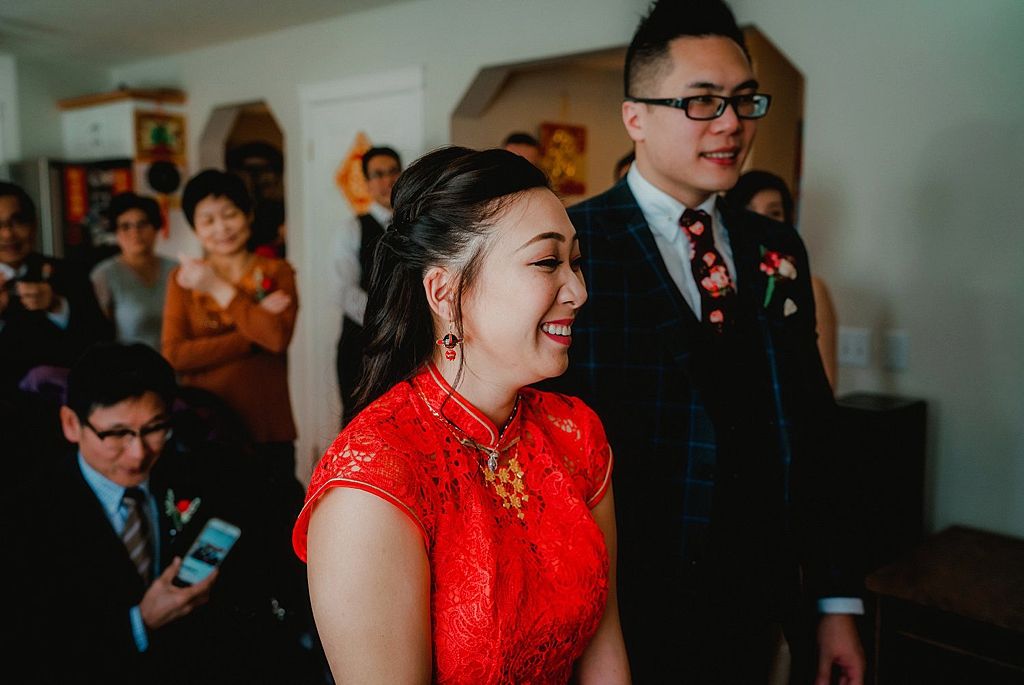Wedding celebration scene with traditional red Chinese attire and formal wear.