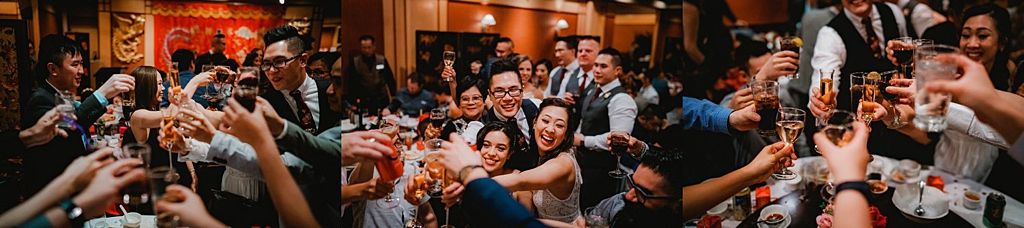 Wedding guests raising toast glasses during lively reception celebration.