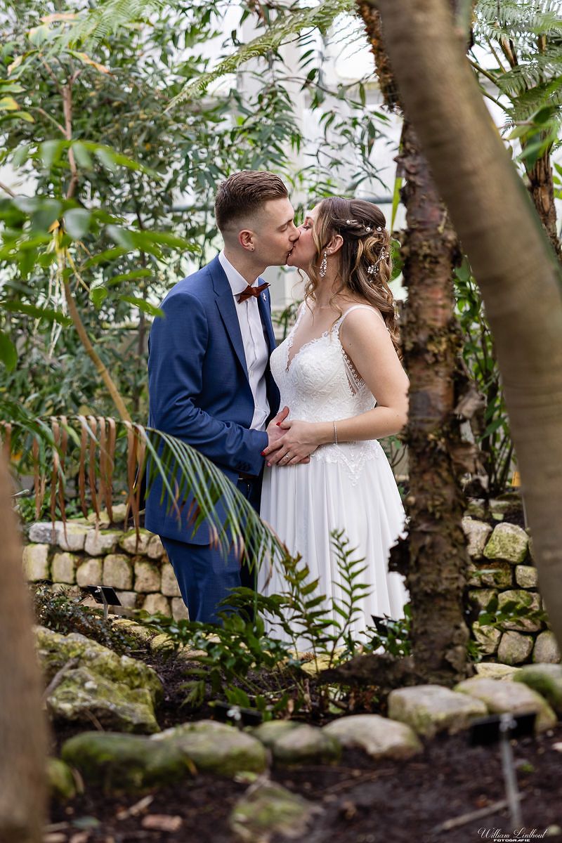 Couple sharing a romantic moment in a lush garden setting.