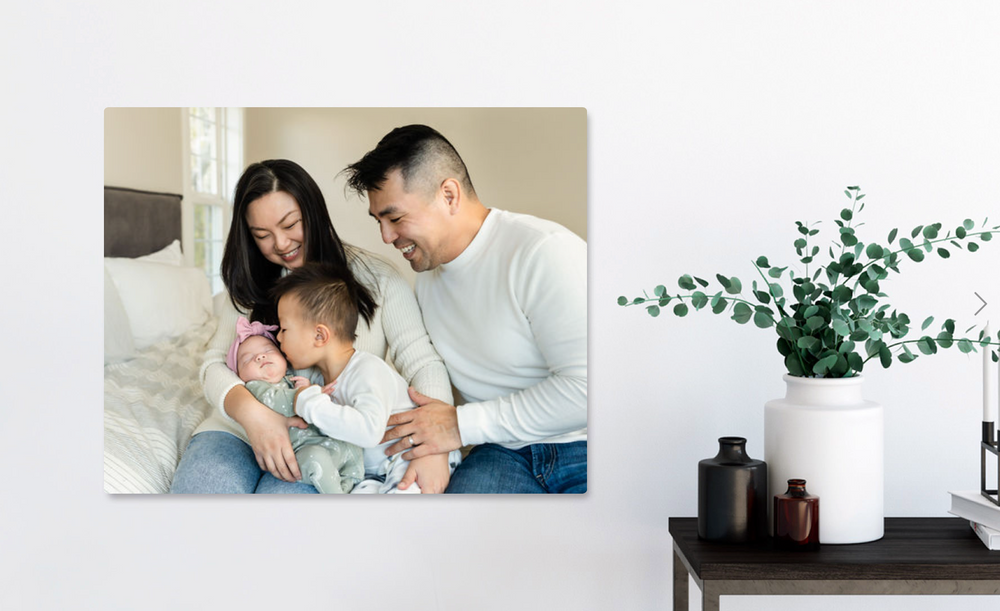 Living room with metal print of family cuddling with newborn baby girl