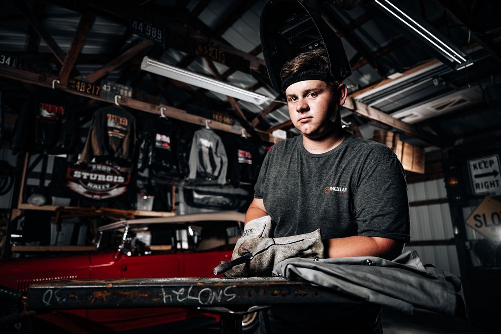 Mechanic working in automotive repair shop with tools and equipment.