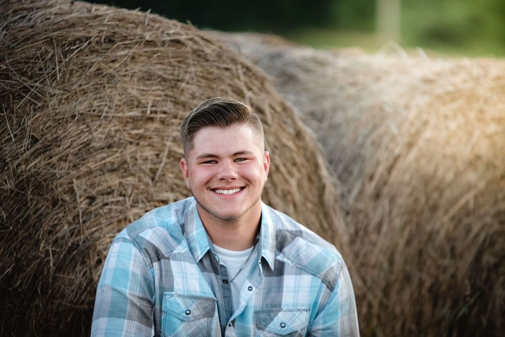 Senior guy plaid shirt and hay bales