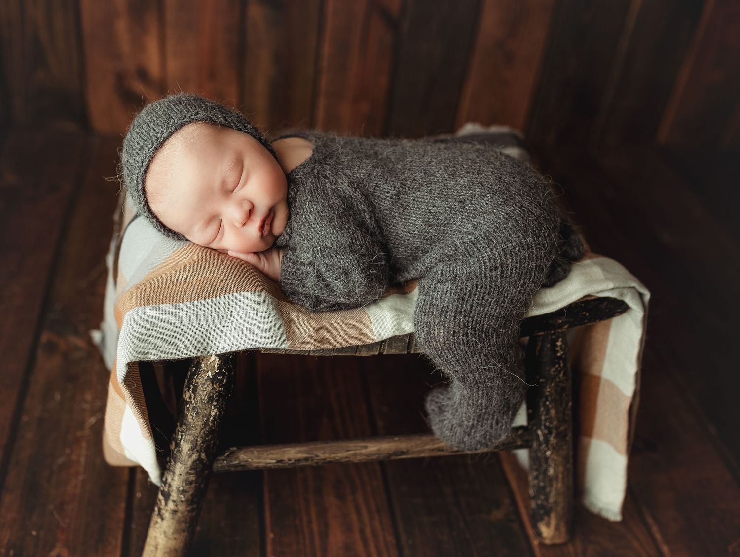 Newborn on a stool in a gray footie outfit. Greenville, SC newborn photographer; Easley, SC newborn photographer, Upstate newborn photograp