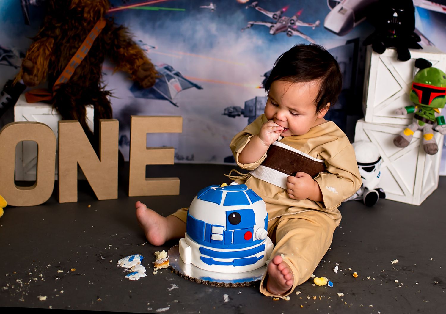 Baby boy eating his Star Wars themed cake for first birthday session