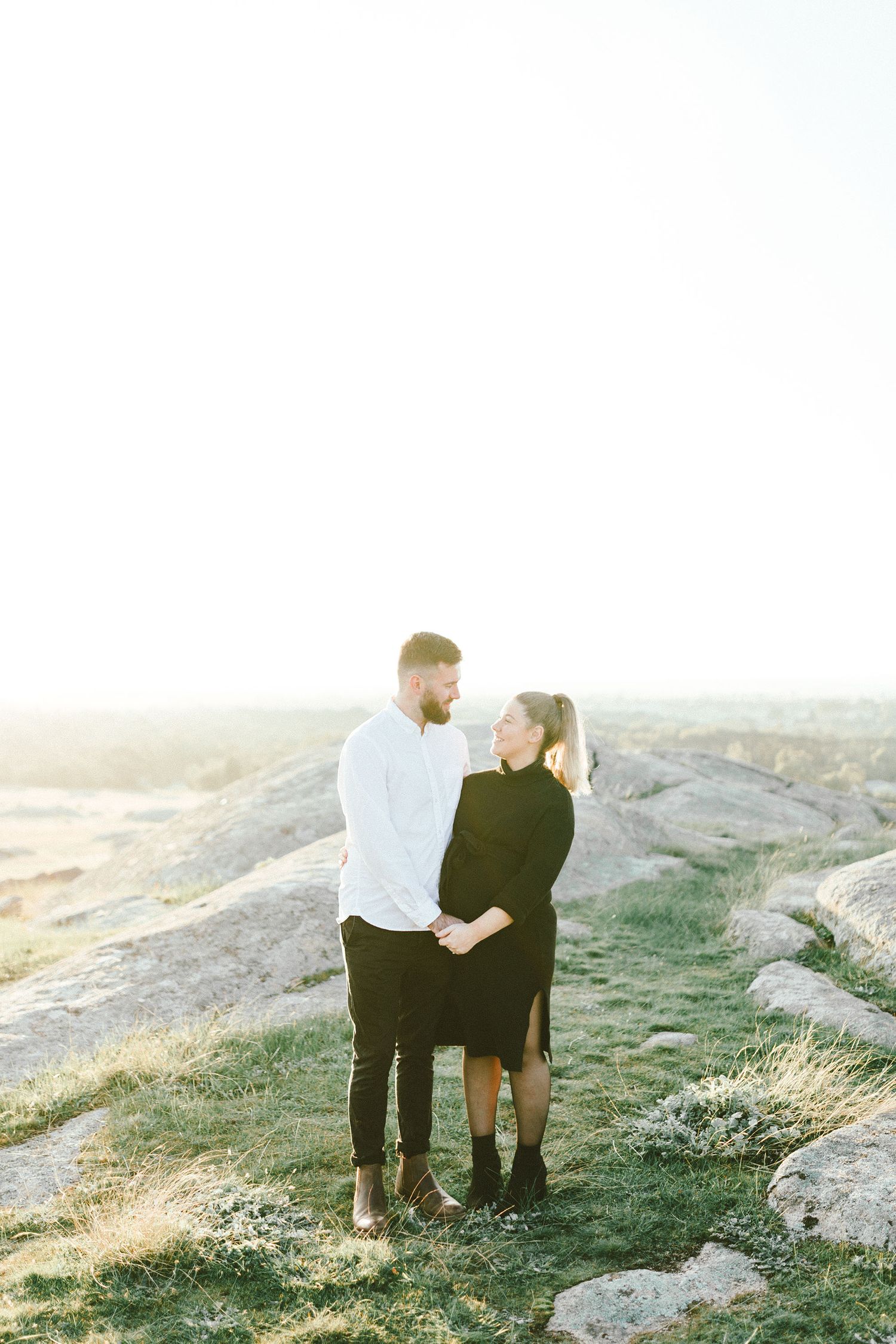A tender moment between two people against a sunlit desert landscape.