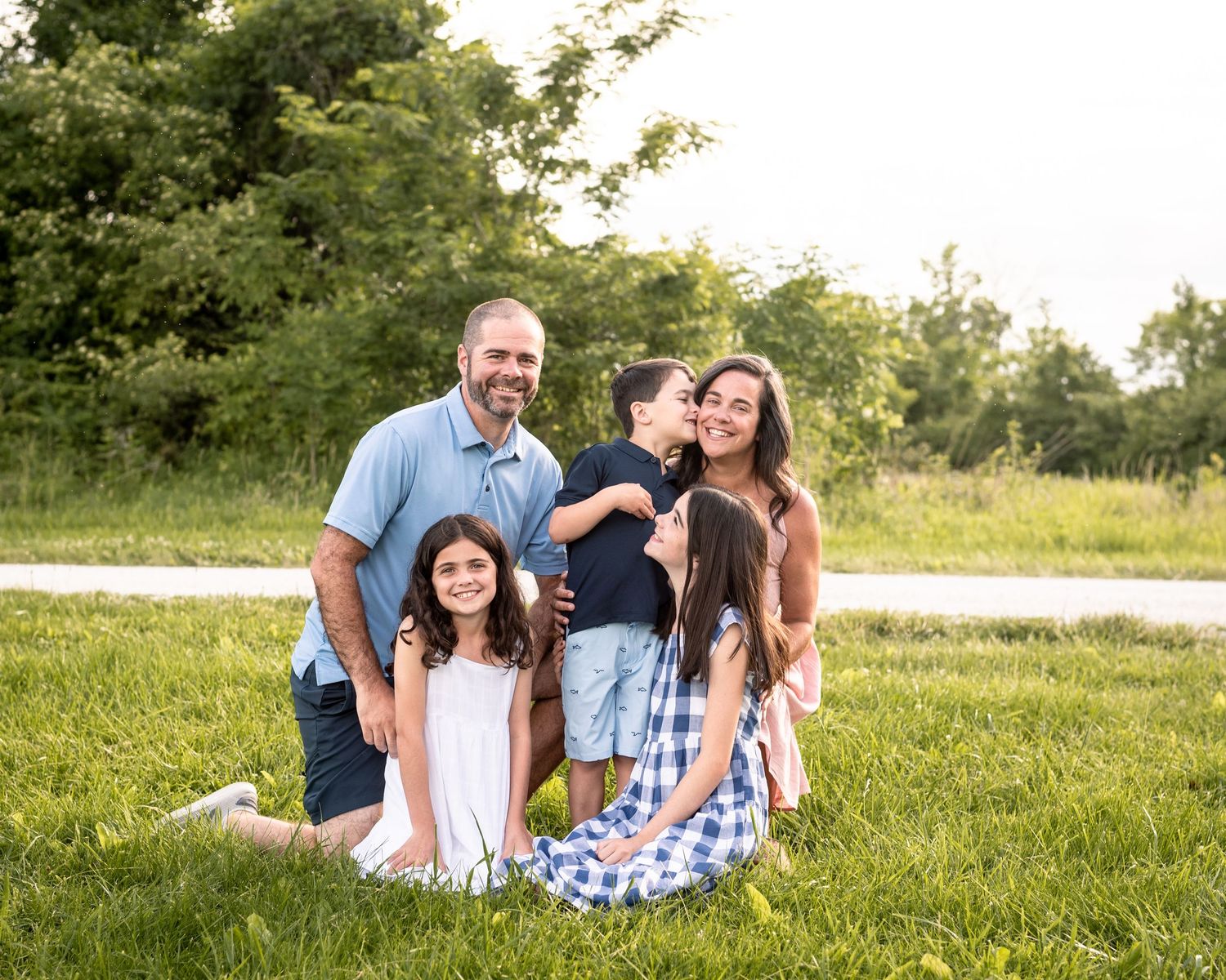 Lifestyle photograph of a family dressed in pink and blue outside of St. Louis