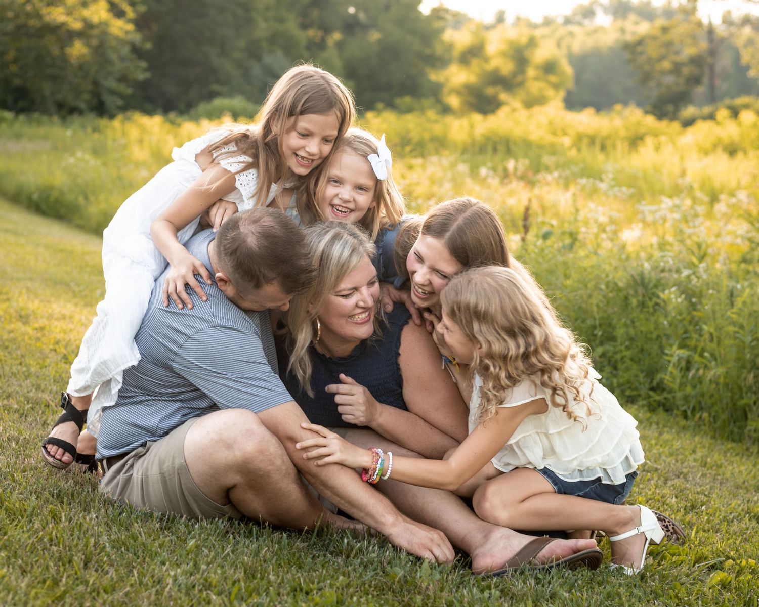 Photography of a family laughing together in the fields outside of St. Louis