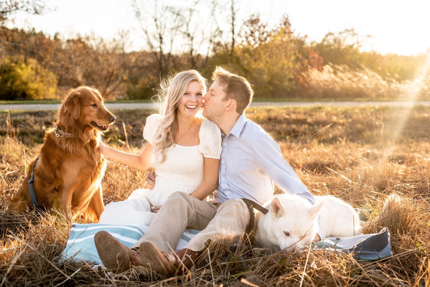 Christmas card worthy photo of a pregnant mom and her husband with their dogs.