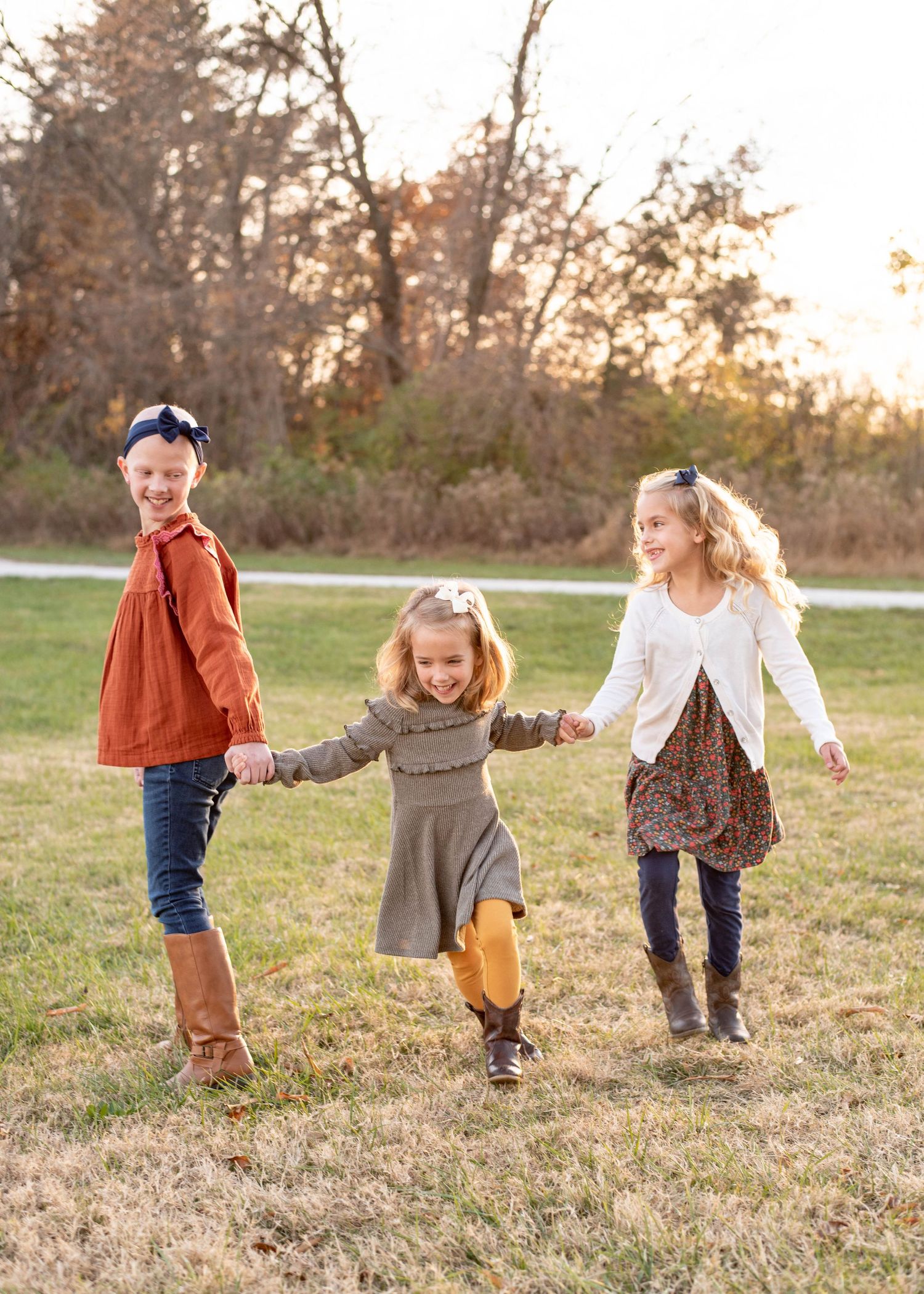 Three young sisters having fun together and pulling each other by the hands.