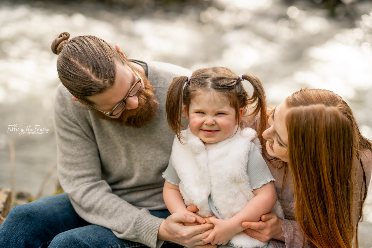 Family sitting together on grass during an intimate outdoor photo session.