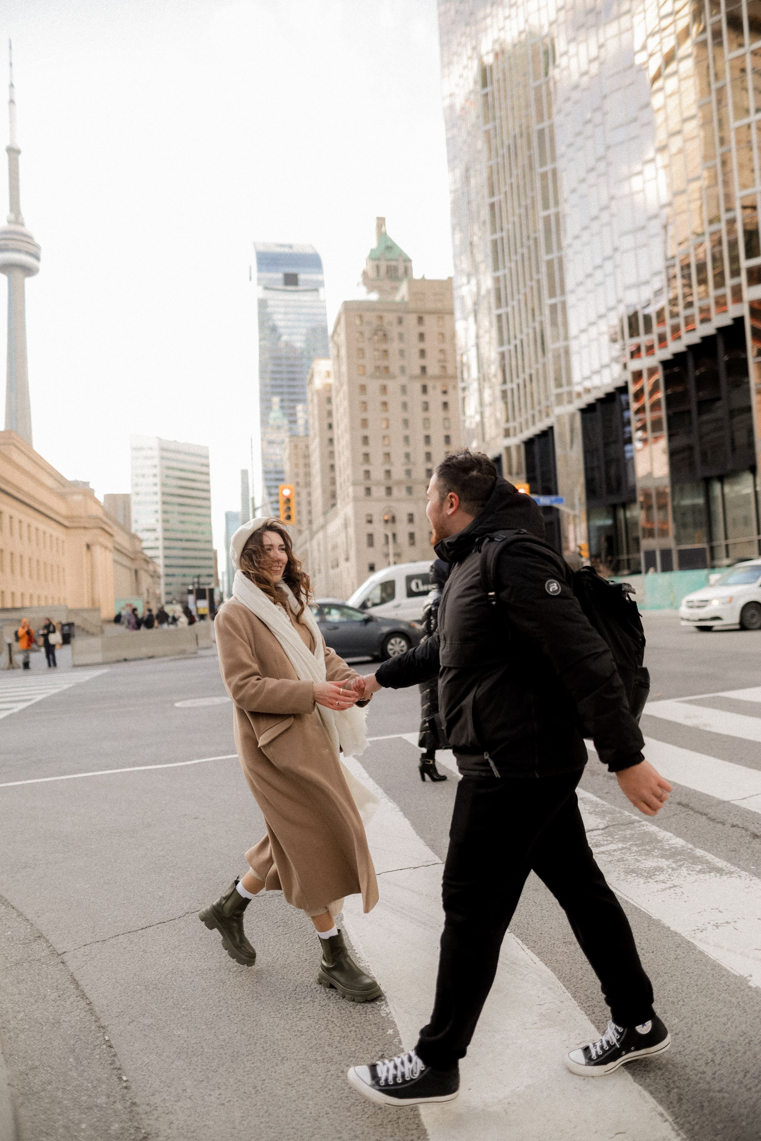 A couple dancing on a Toronto street with the CN Tower visible in the background.