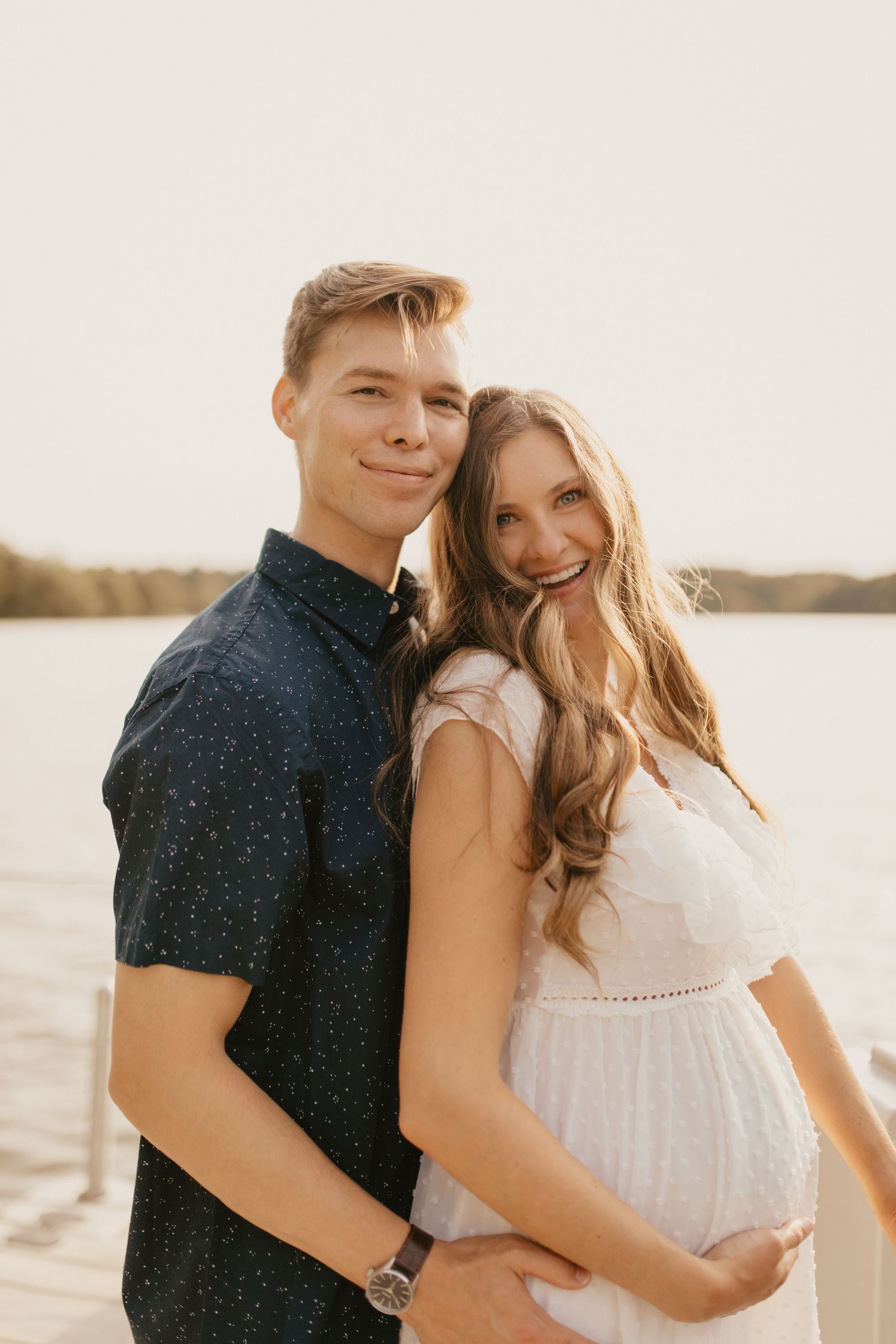 Couple shares loving moments by the water during golden hour.