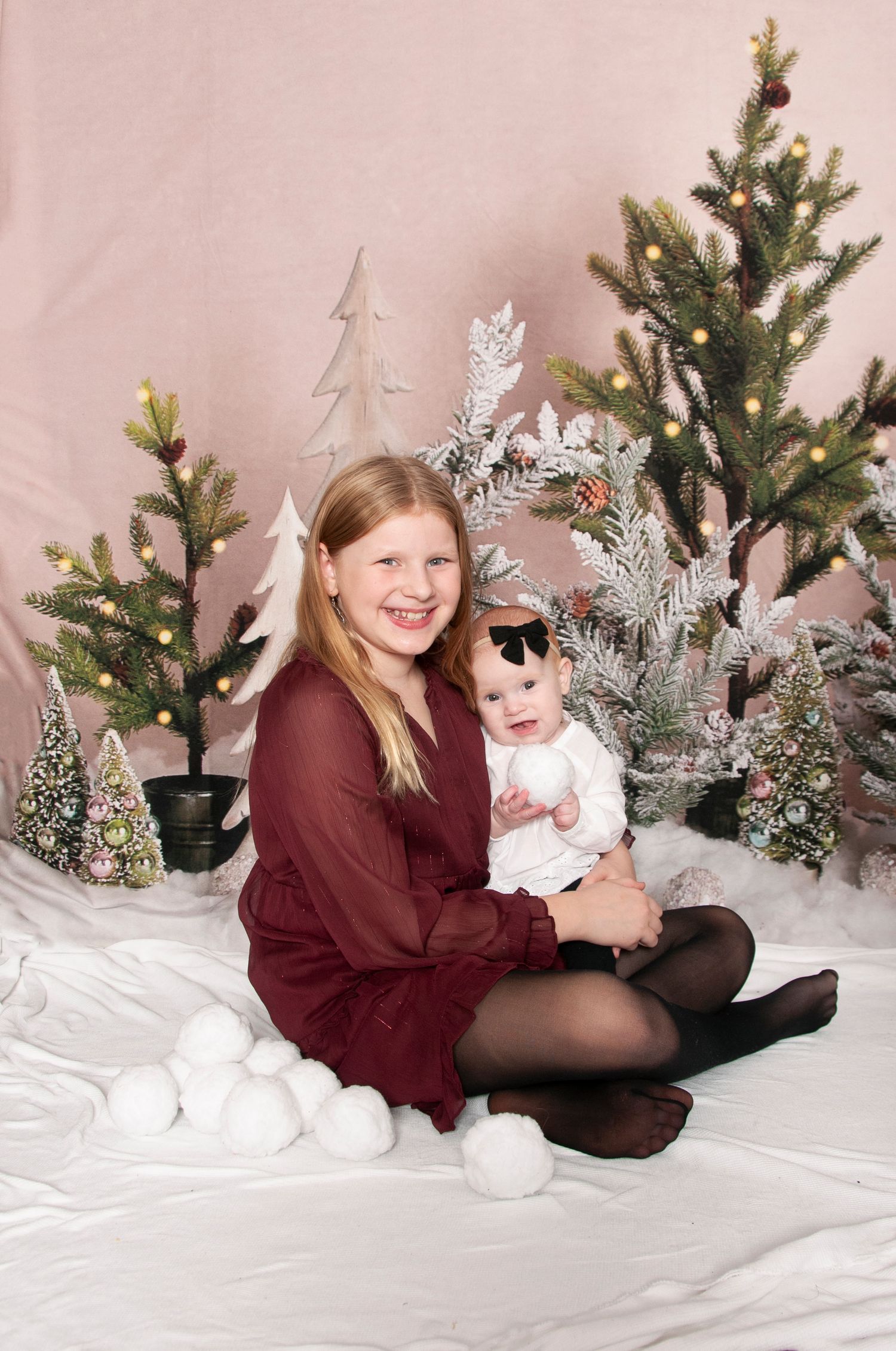 Older sister holding infant studio backdrop set up