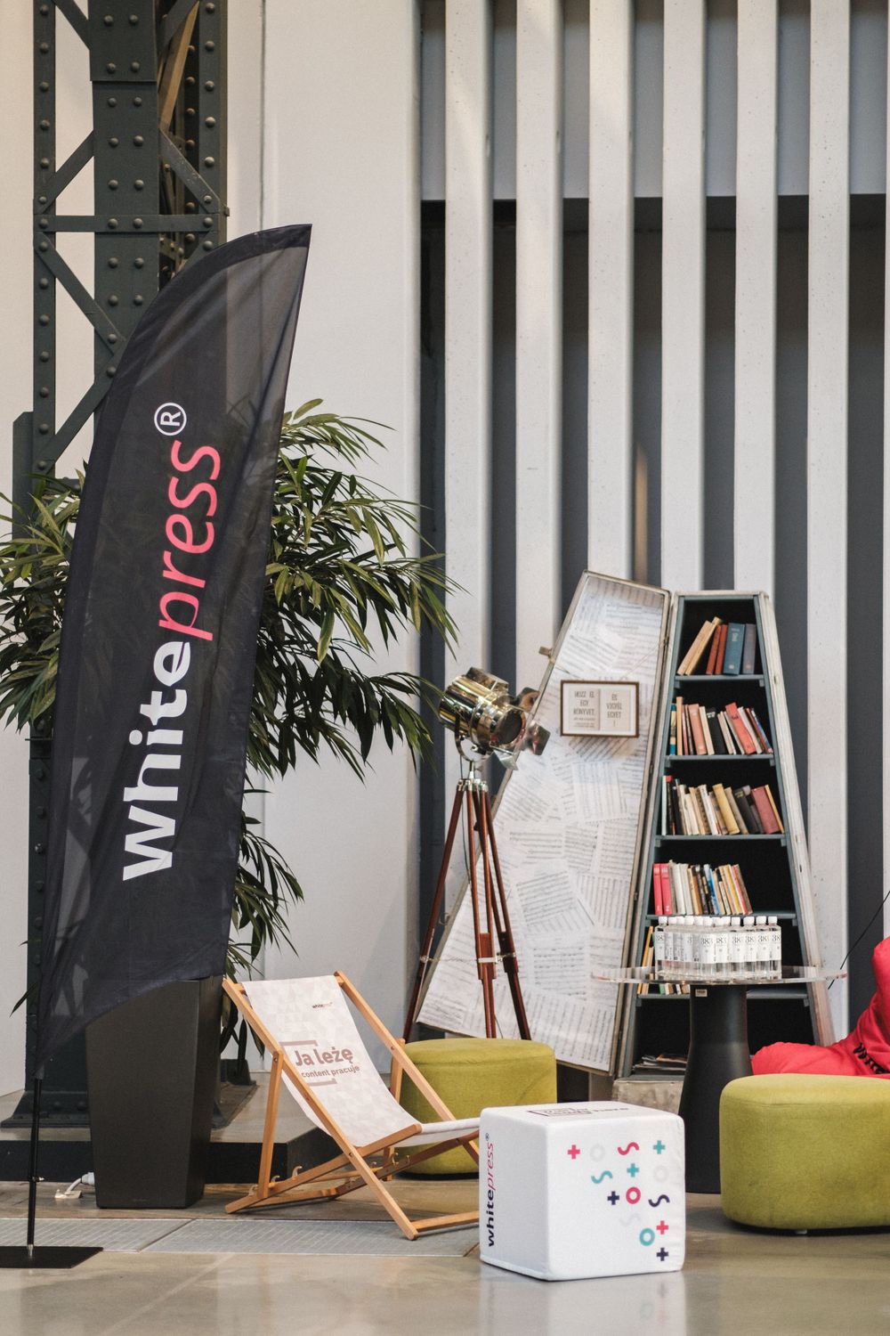 Whitepress banner flag next to bookshelf and casual seating area.
