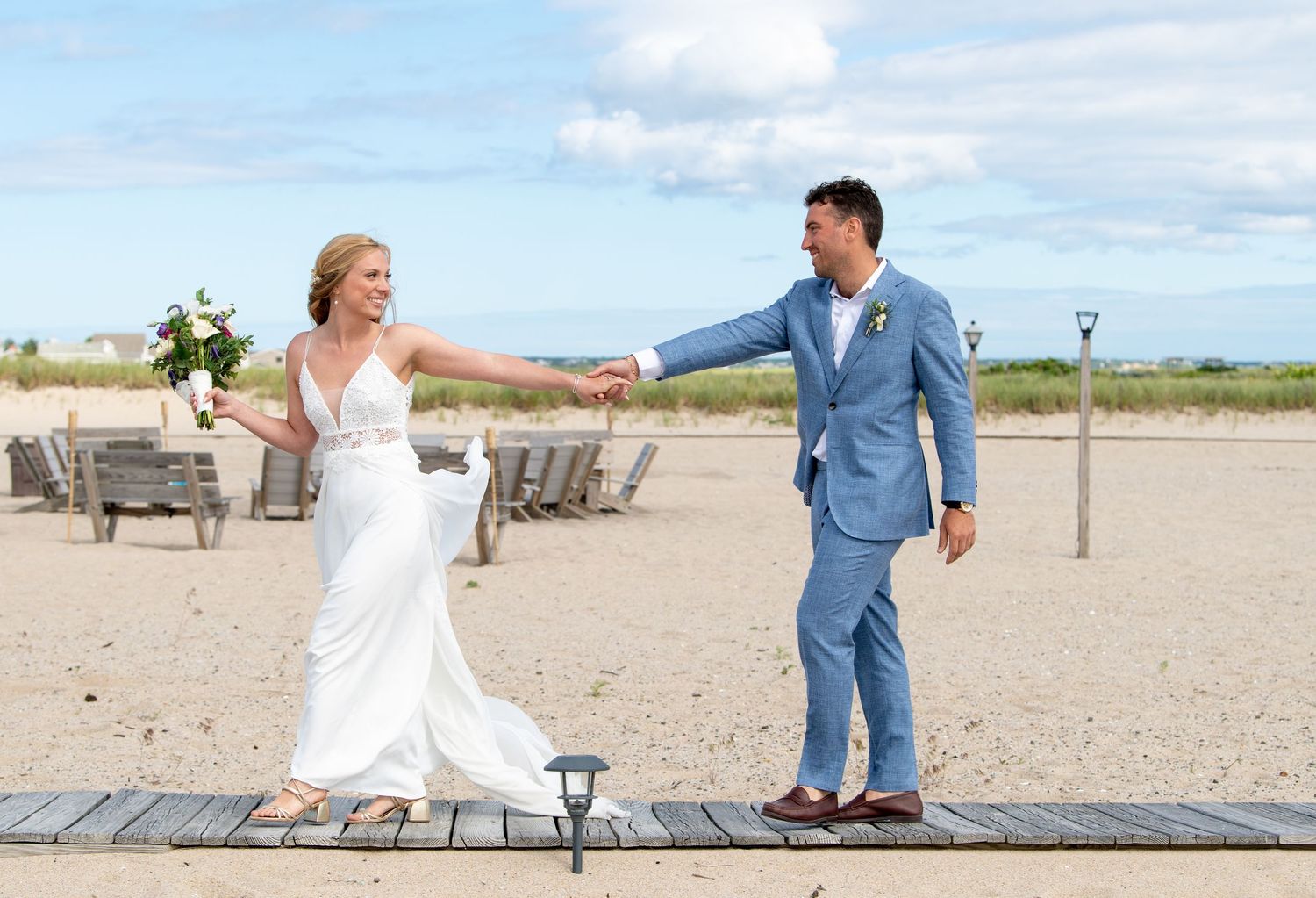 Couple enjoying a romantic moment on a wooden boardwalk at the beach.