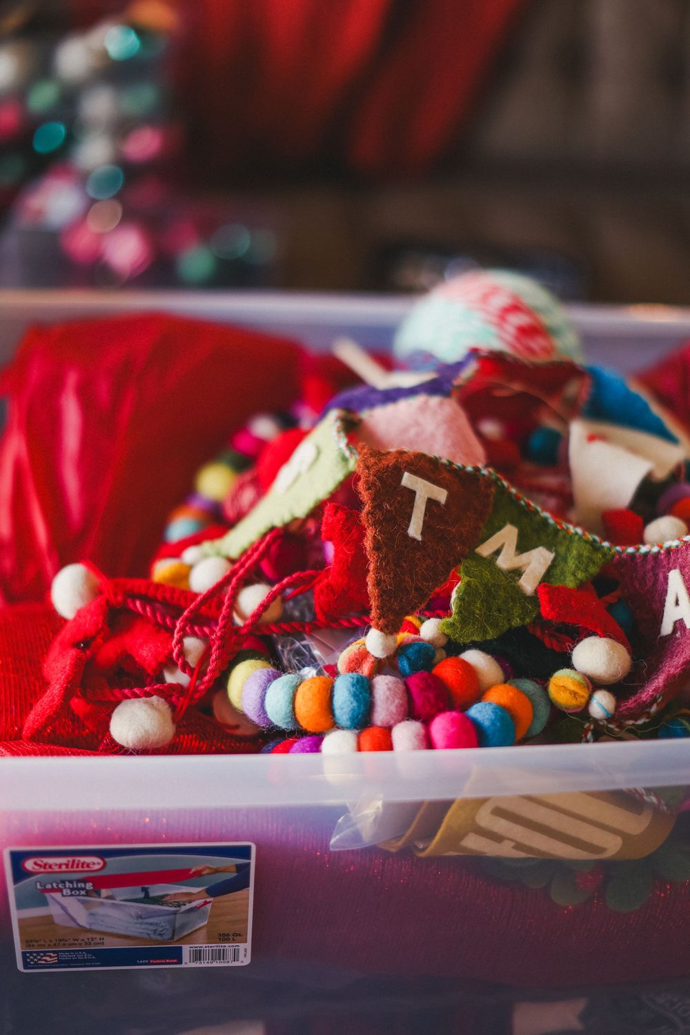 Colorful Christmas ornaments and decorations arranged in clear plastic storage containers.
