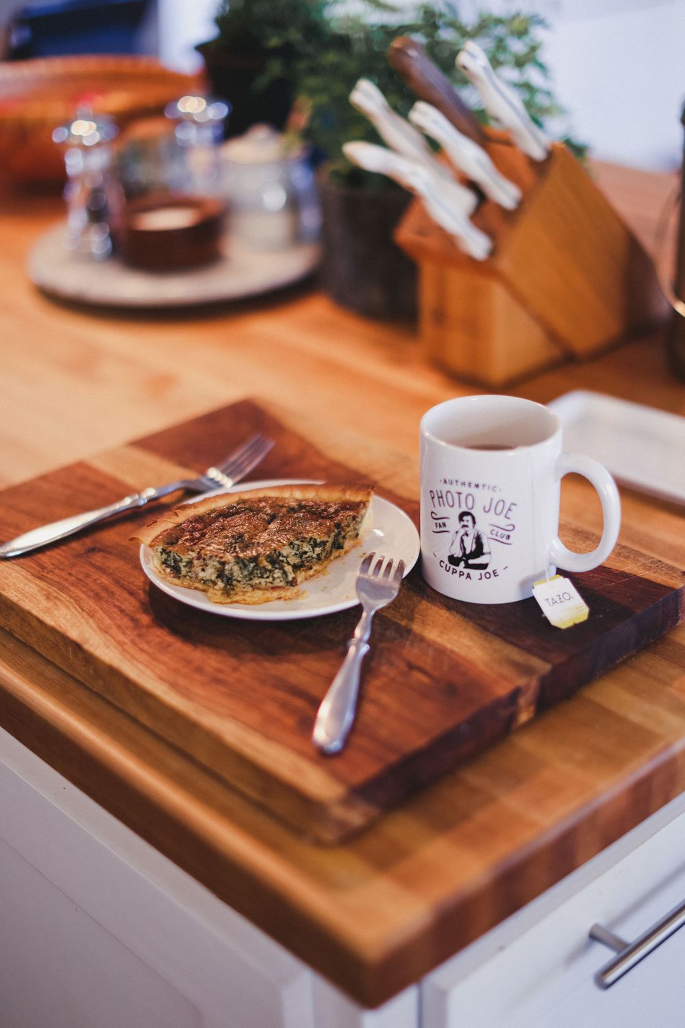 Tea and breakfast served on a rustic wooden cutting board.