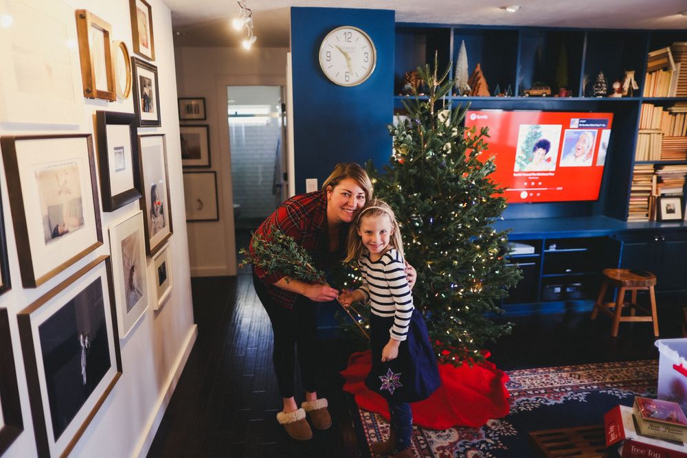 Panoramic view of a living room with blue walls, Christmas tree, and framed artwork.