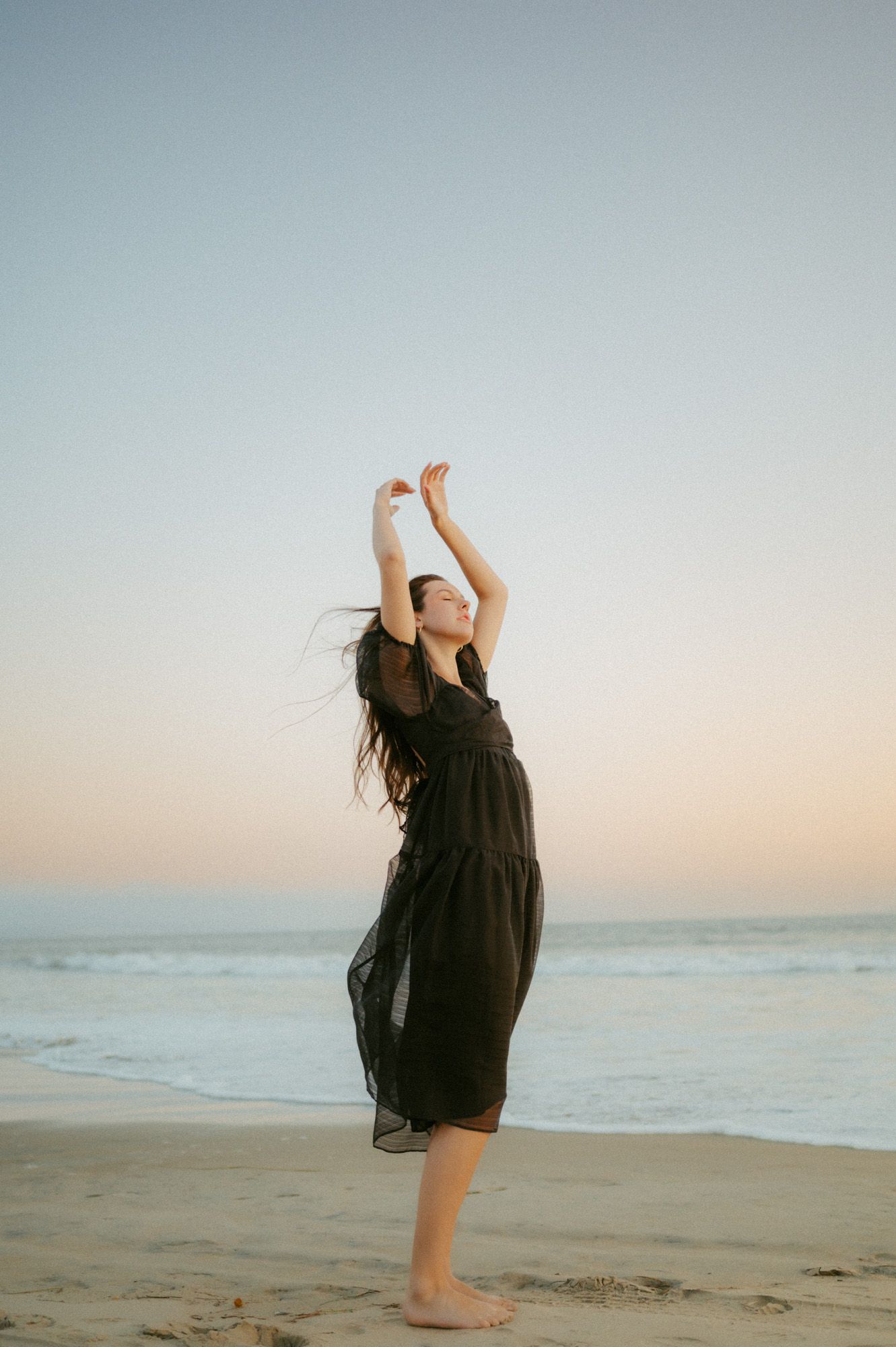 Senior Grad portrait at Coronado Beach taken by Del Mar photographer, Tiffany Kelterer, of girl embracing the wind