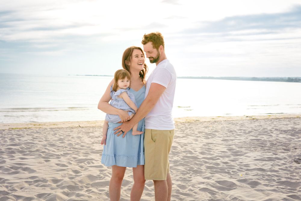 Loving family shares joyful moment together on sunny beach.