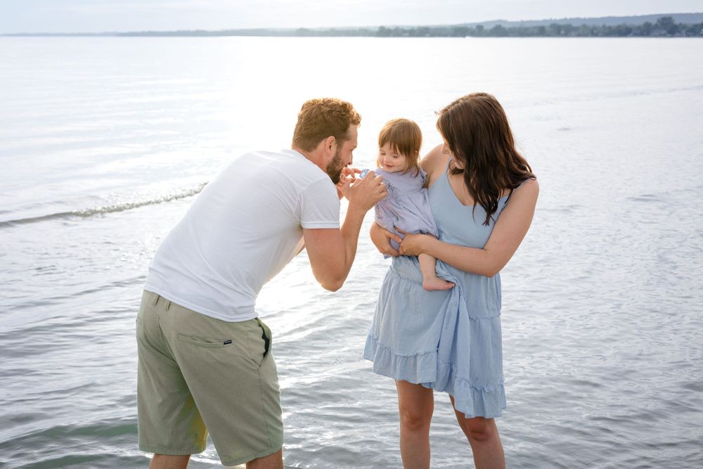 Family sharing intimate moment together by the water.
