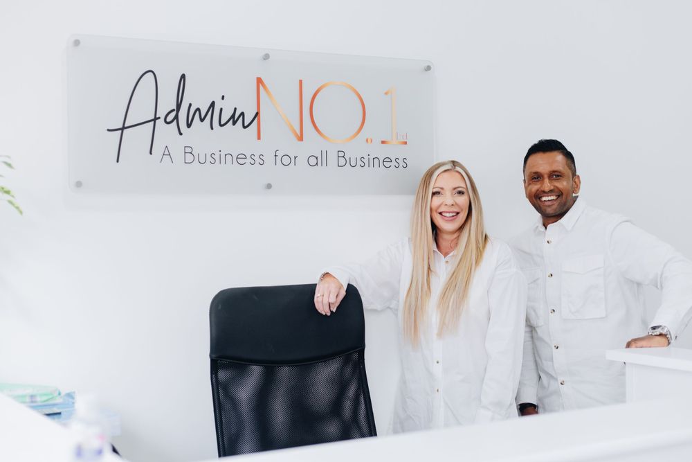 Business team posing together under Admin NO.1 company sign in bright office setting.