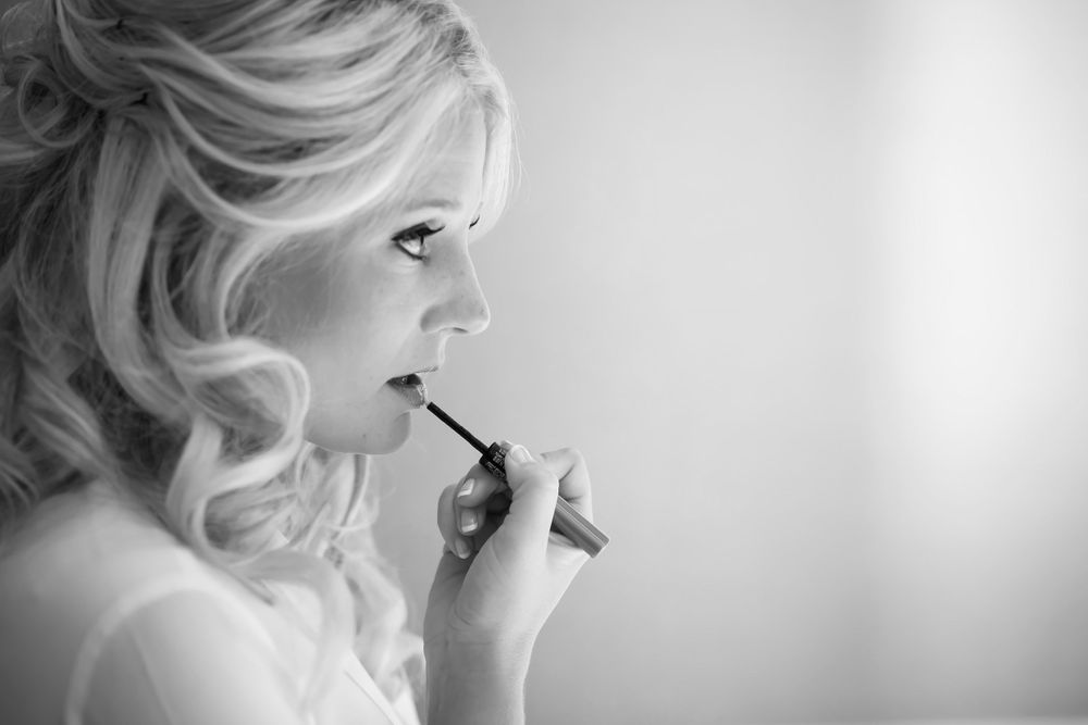 Bride applies lipstick on wedding day in Cleveland, Ohio.