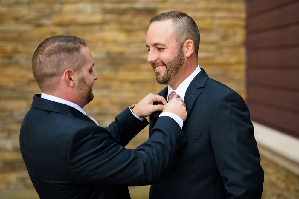 Best man adjusts groom's tie before wedding ceremony in Cleveland, Ohio.