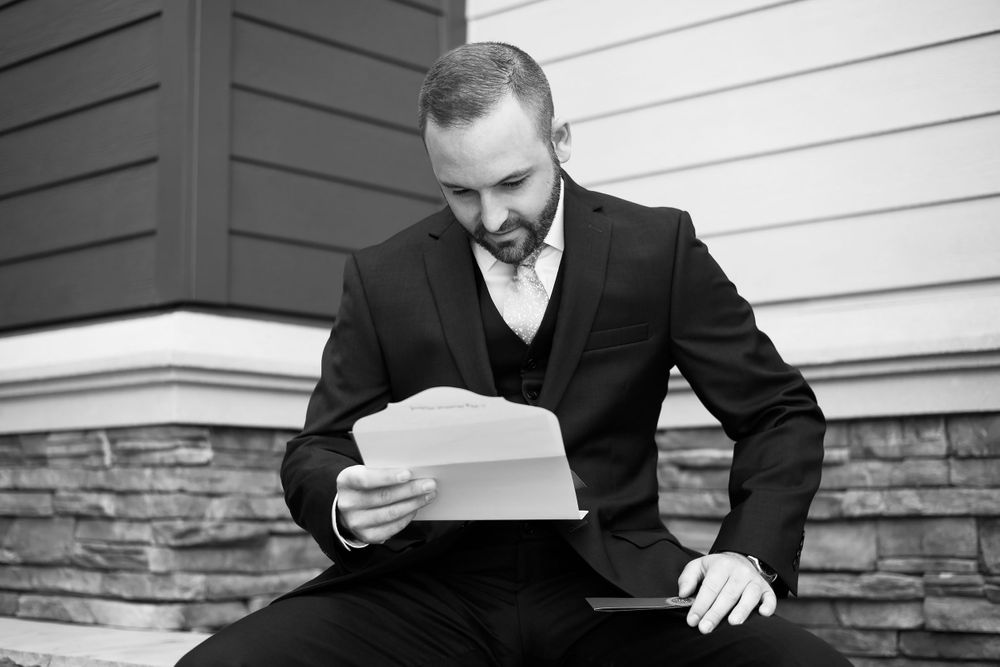 Groom reads letter from bride before their wedding ceremony in Cleveland, Ohio.