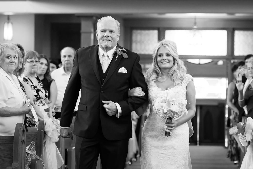Bride and her father walk aisle.