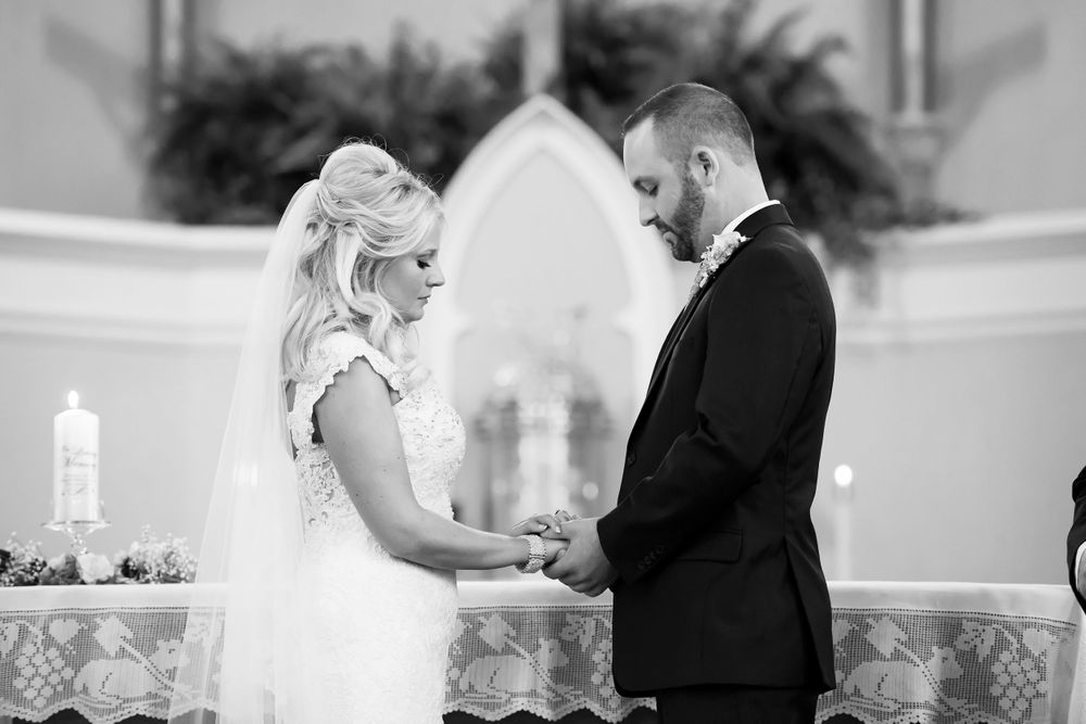 Bride and groom exchange vows during wedding ceremony at Saint Mary Parish in Elyria, Ohio.