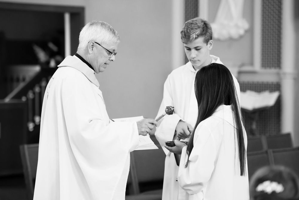 Priest blesses wedding rings during ceremony at Saint Mary Parish in Elyria, Ohio.