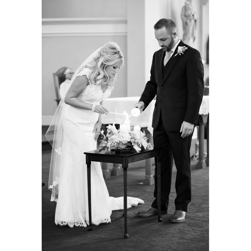 Bride and groom light unity candle during wedding ceremony at Saint Mary Parish in Elyria, Ohio.