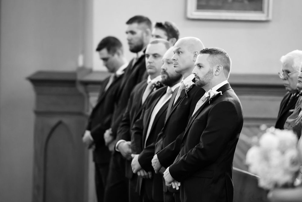 Groomsmen watch wedding ceremony at Saint Mary Parish in Elyria, Ohio.
