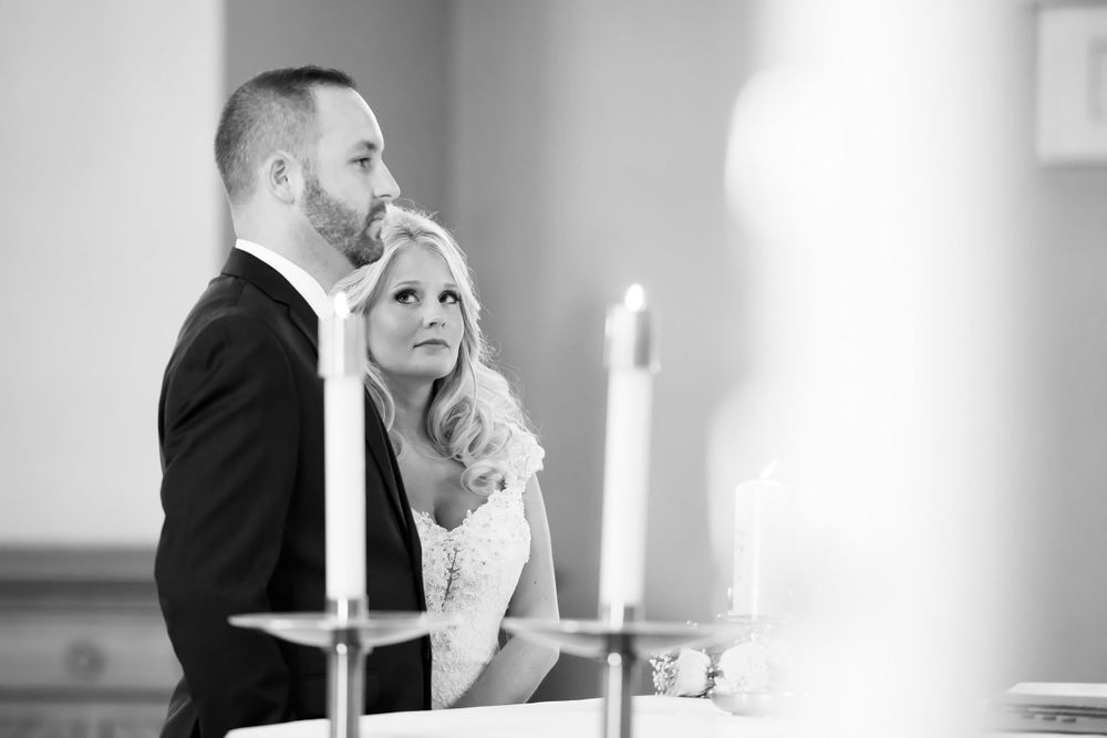 Bride lovingly looks at groom during their wedding ceremony at Saint Mary Parish in Elyria, Ohio.