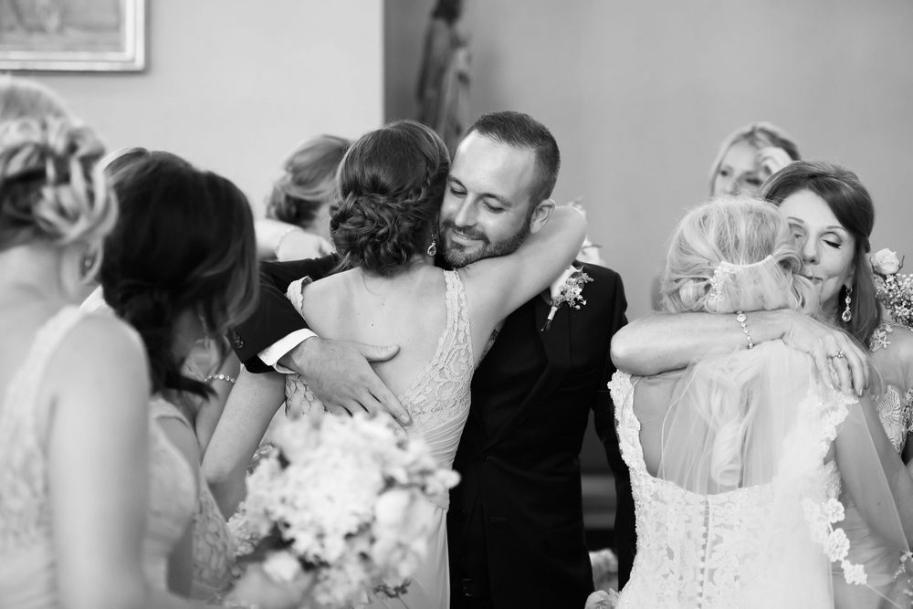 Groom hugs mother during wedding ceremony at Saint Mary Parish in Elyria, Ohio.