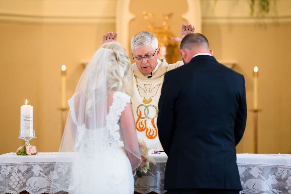 Bride and groom receive communion during wedding ceremony at Saint Mary Parish in Elyria, Ohio.