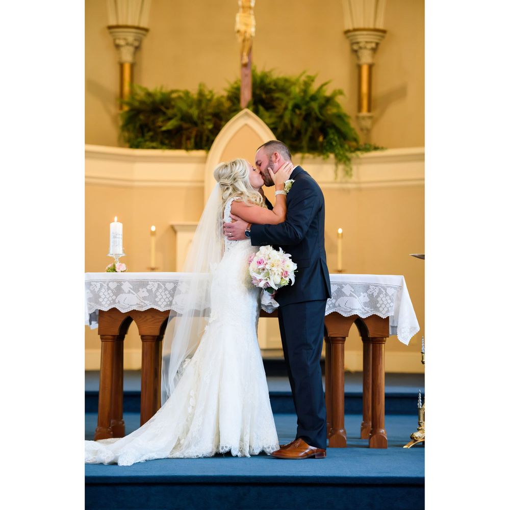 Bride and groom kiss during wedding ceremony at Saint Mary Parish in Elyria, Ohio.
