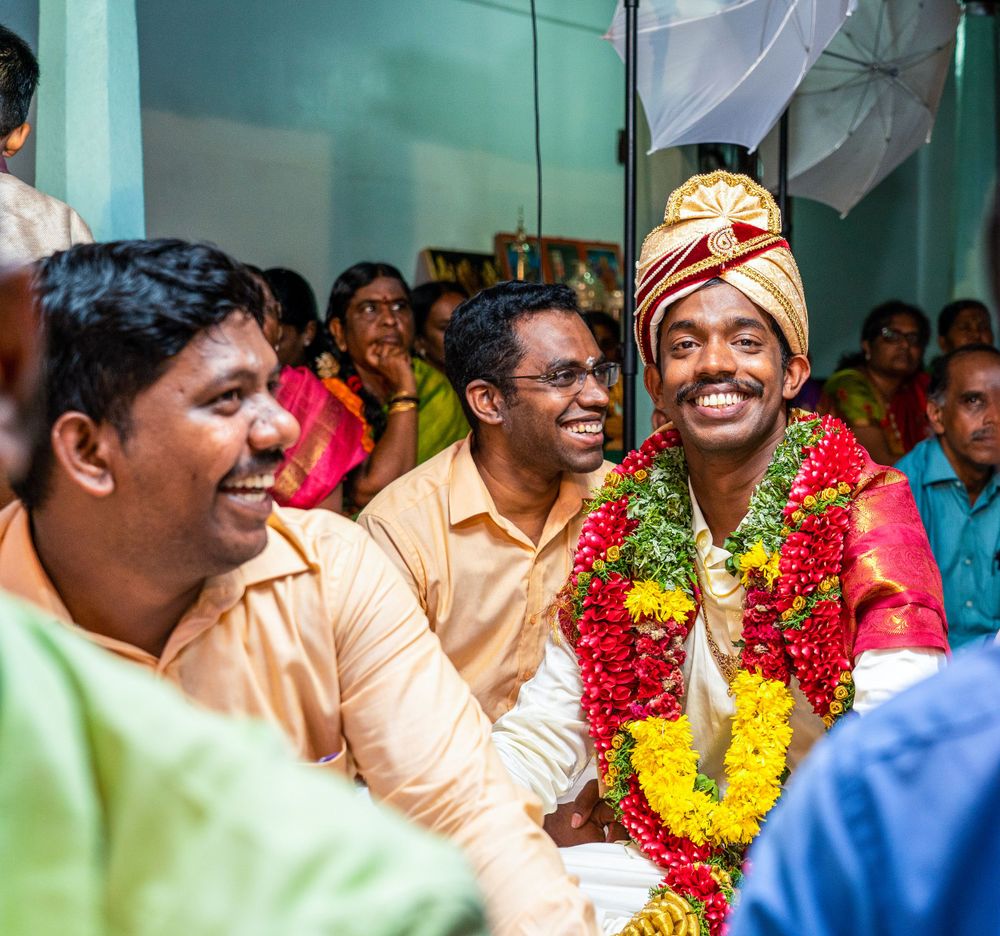 Joyful celebration with participants wearing flower garlands during traditional ceremony.