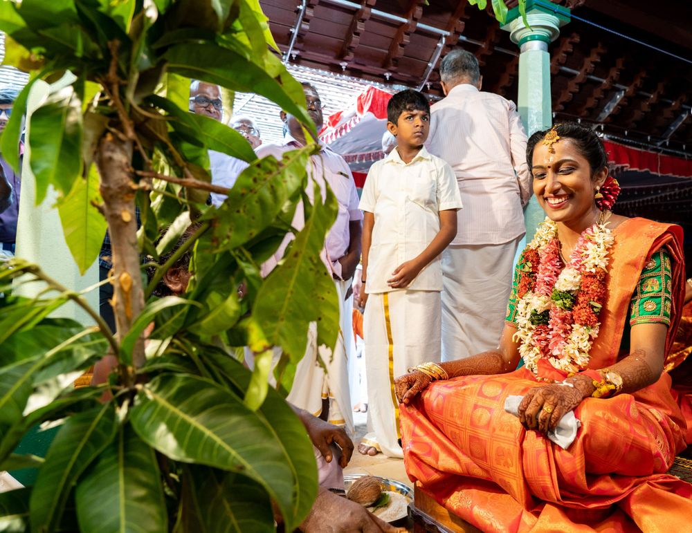 Traditional Kerala wedding setting with decorative plants and bright ceremonial attire.