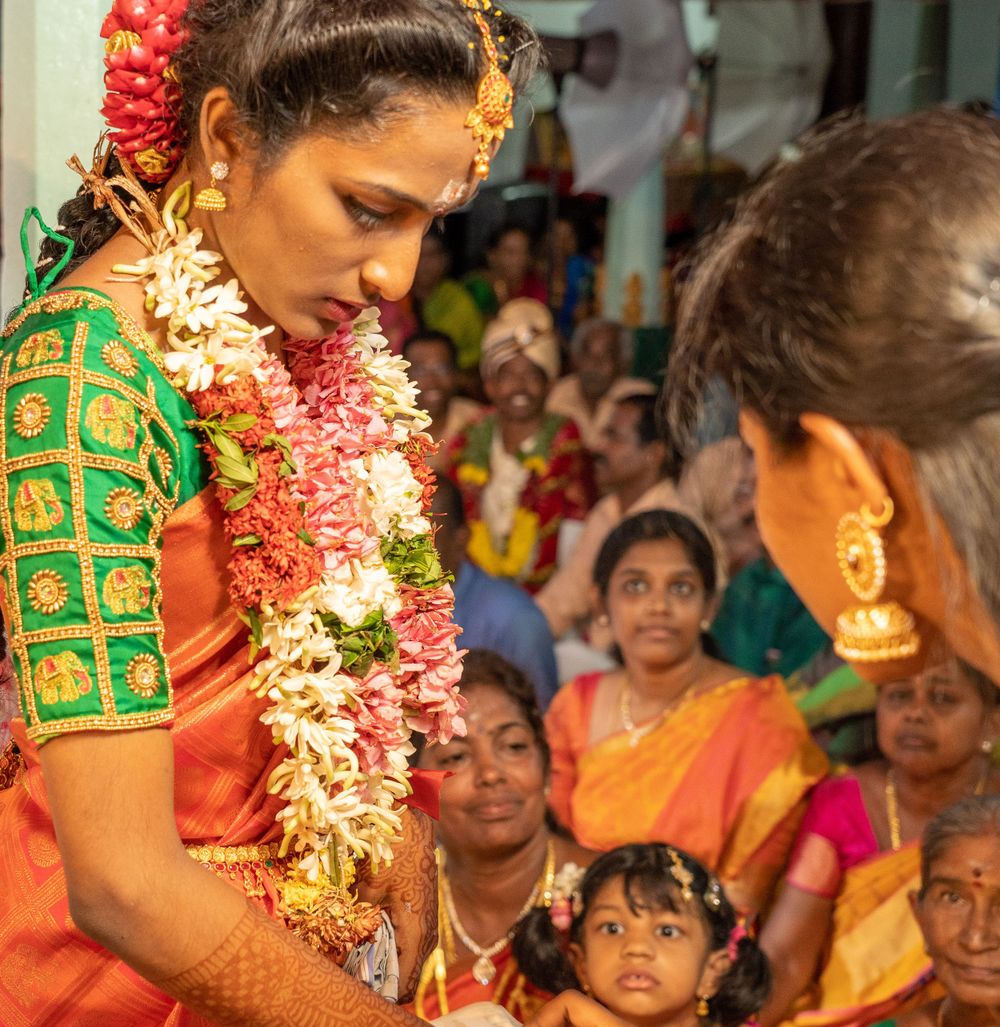 Traditional South Indian wedding with bride wearing ornate green blouse and flower garlands.