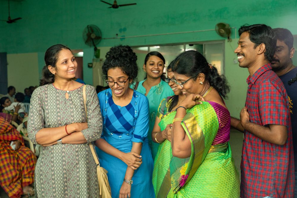 Group of guests in colorful attire sharing a lighthearted moment at a celebration.