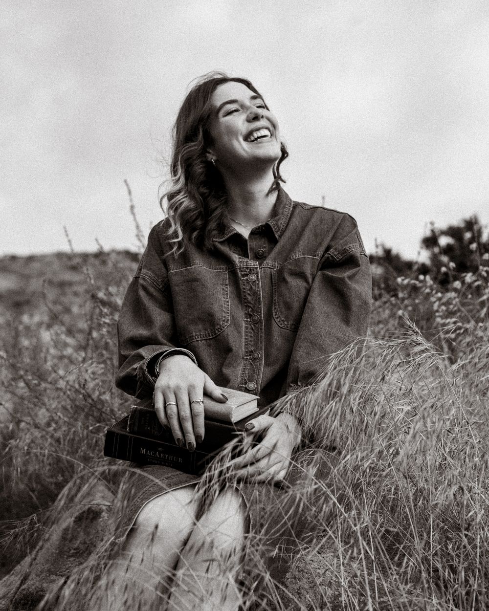 Black and white portraits taken in a field of tall grass showing natural joy.