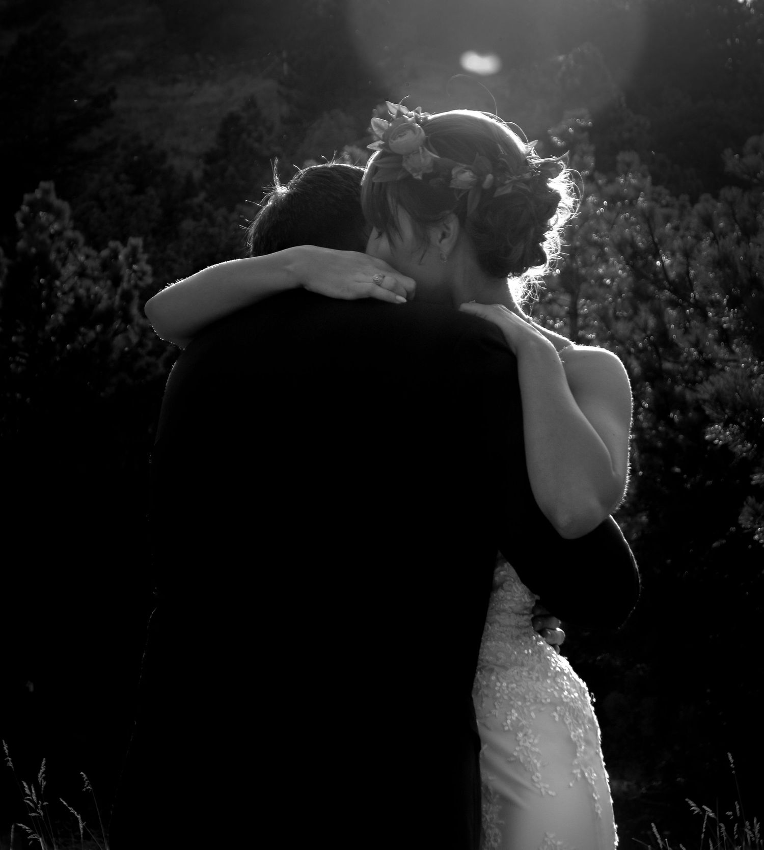 Silhouette of a romantic embrace against a dark background outdoors.