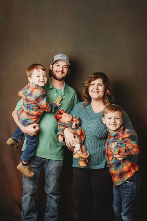 A playful family studio portrait with everyone wearing casual clothes and bright smiles.