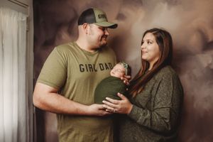 Casual family photo session with parents in earth tones sharing tender moments with their baby.